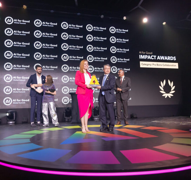 Man presenting an award to a woman on stage at an event.